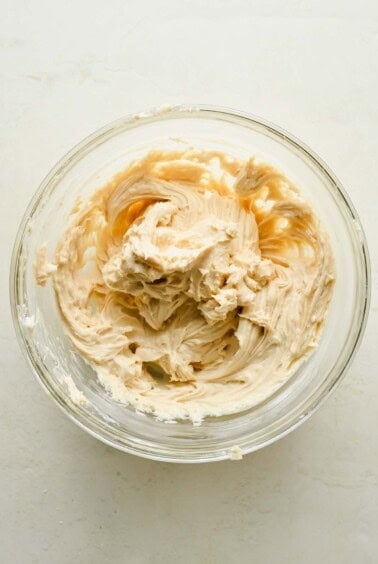 Cream cheese filling mixed with brown sugar and vanilla in a glass bowl