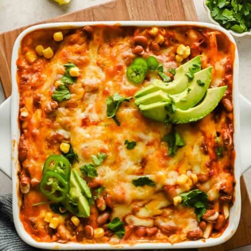 Overhead square crop of baked, cheesy tortilla folds with pinto beans, corn, avocado, jalapeño, and cilantro.