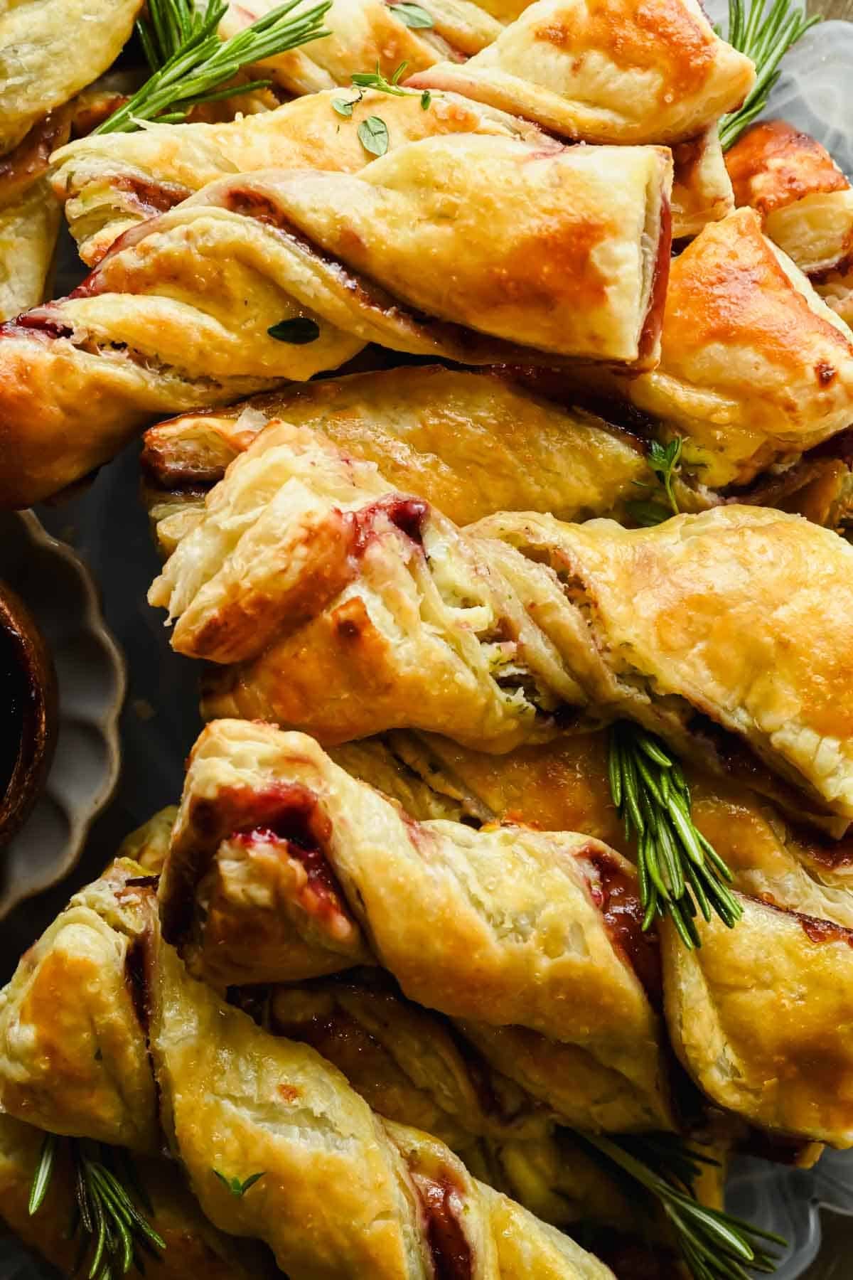 Close-up of flaky golden puff pastry twists with blackberry jam and Boursin filling.