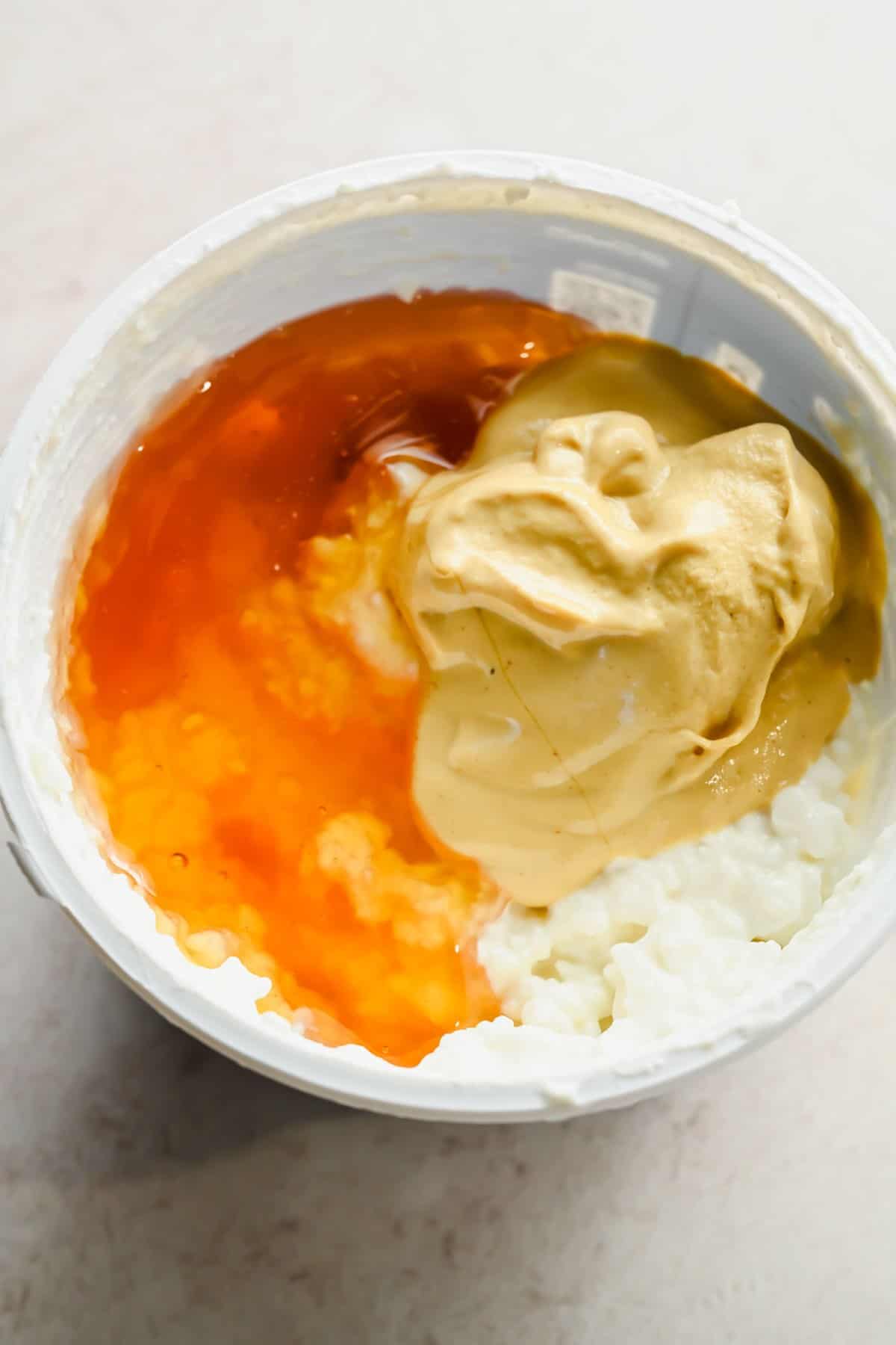 Cottage cheese, honey, and Dijon mustard in a bowl before blending.