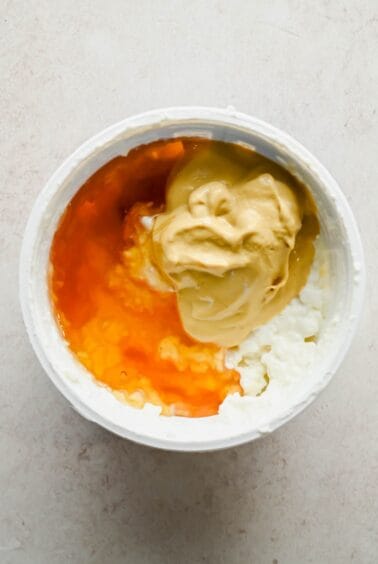 Cottage cheese, honey, and Dijon mustard in a bowl before blending.