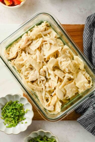 Microwave chicken enchilada with melted Monterey Jack cheese in a glass container.