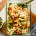 Single-serve microwave chicken enchilada with melted cheese, tomatoes, and cilantro.