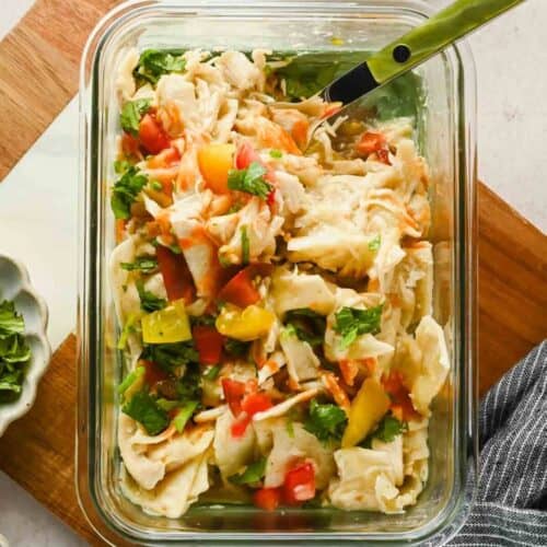 Single-serve microwave chicken enchilada with melted cheese, tomatoes, and cilantro.